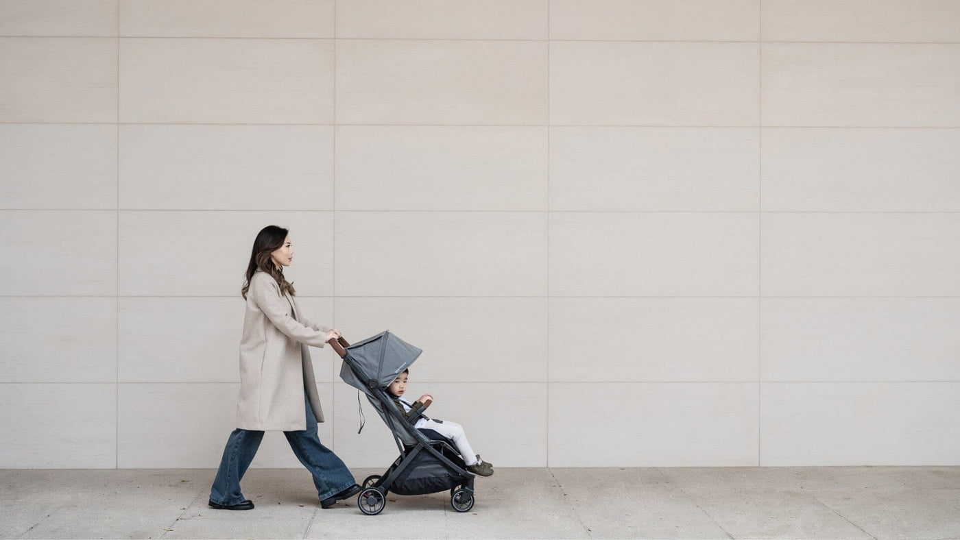 Mom pushing a toddler in the UPPAbaby Minu V3 in a city