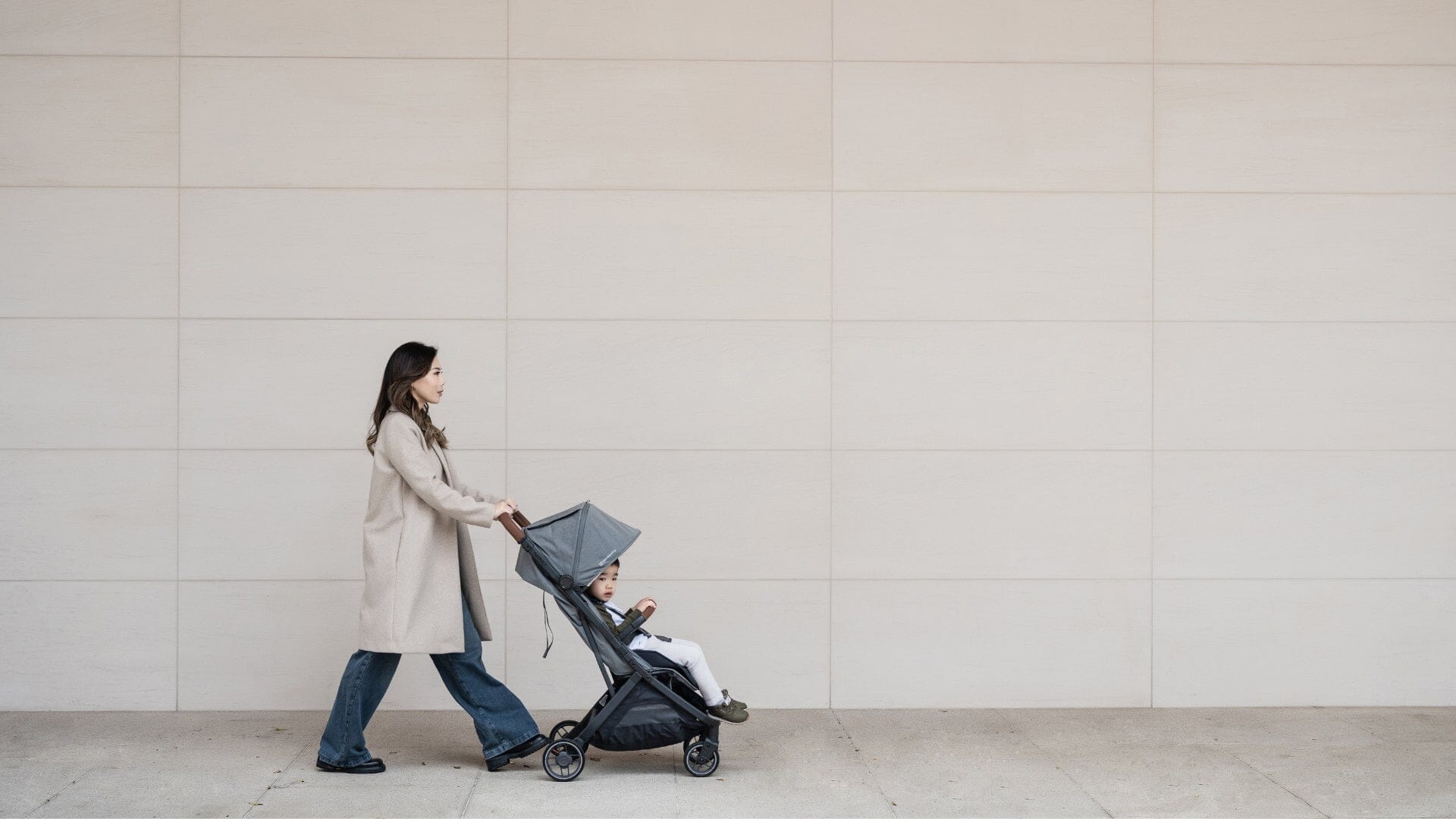 Mom pushing a toddler in the UPPAbaby Minu V3 in a city
