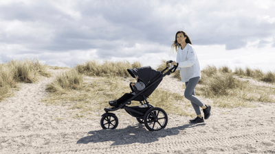 Woman pushing Urban Glide jogging stroller thru sand