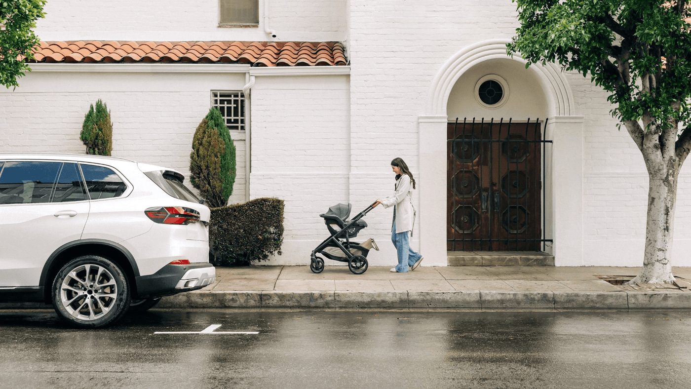 Mom pushing infant in UPPAbaby Vista V3 with UPPAbaby Aria infant car seat