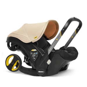 Sahara Sand Doona+ Infant Car Seat with Built-In Wheels in Car Seat Mode - 3/4 Front View | Strolleria