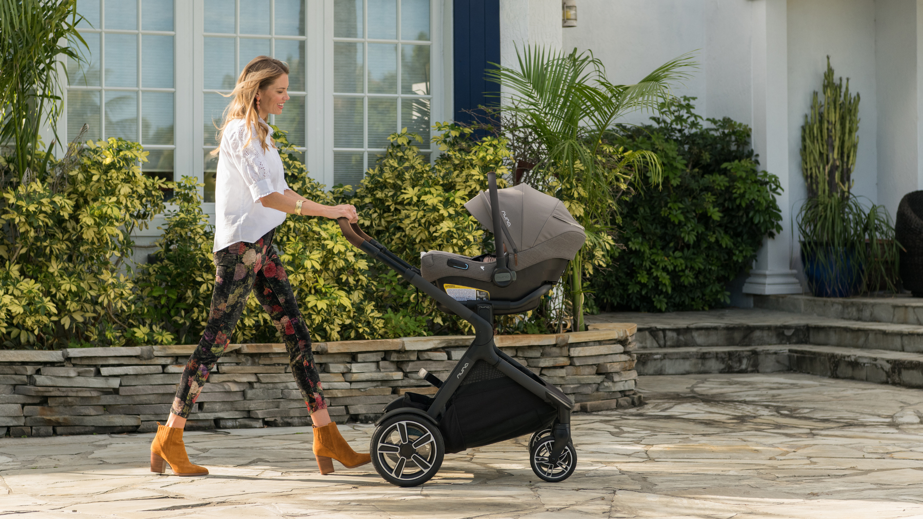 A Mother Taking Her Child for A Walk in A Nuna Stroller